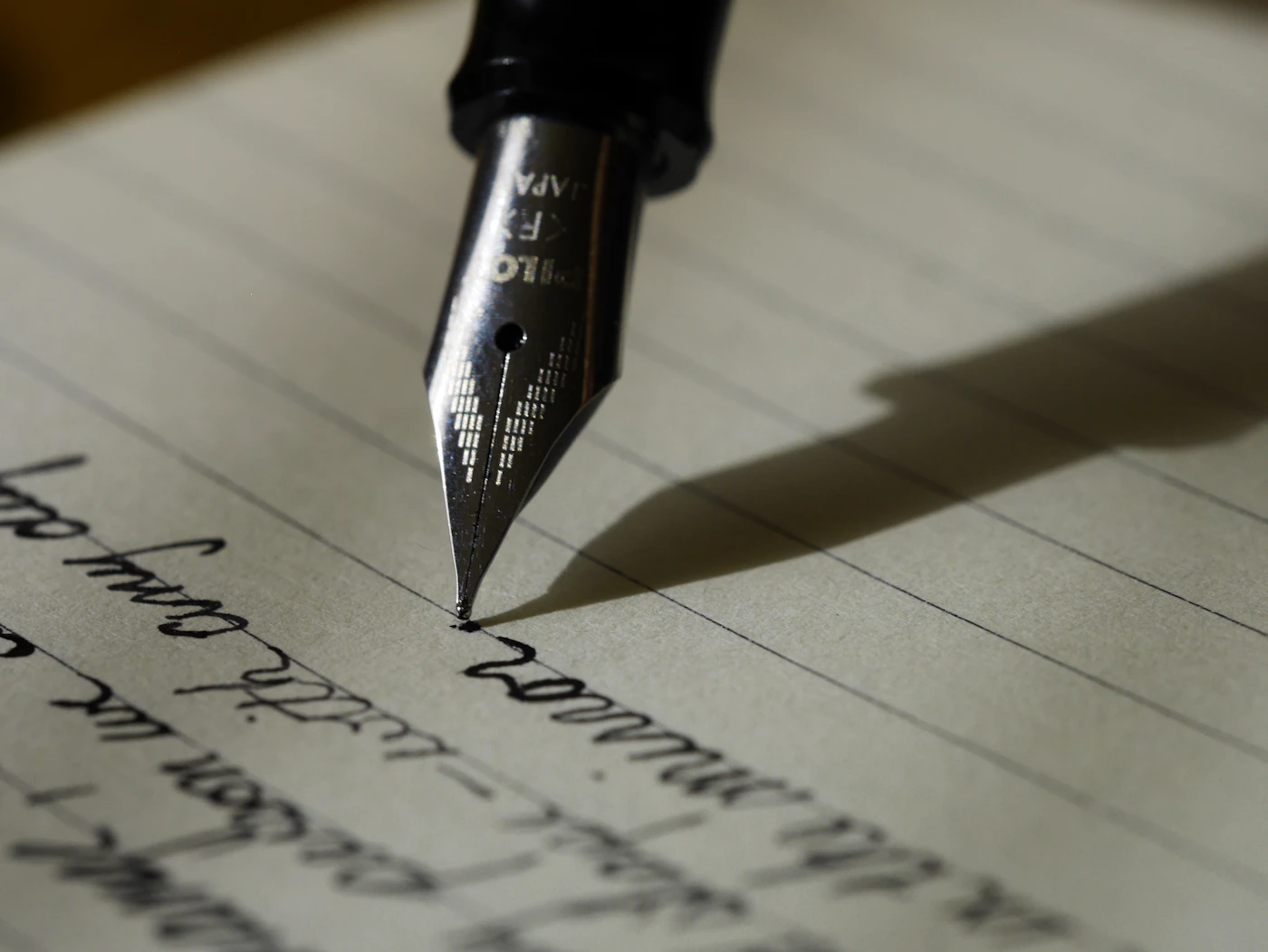 A fountain pen drafting on a written page
